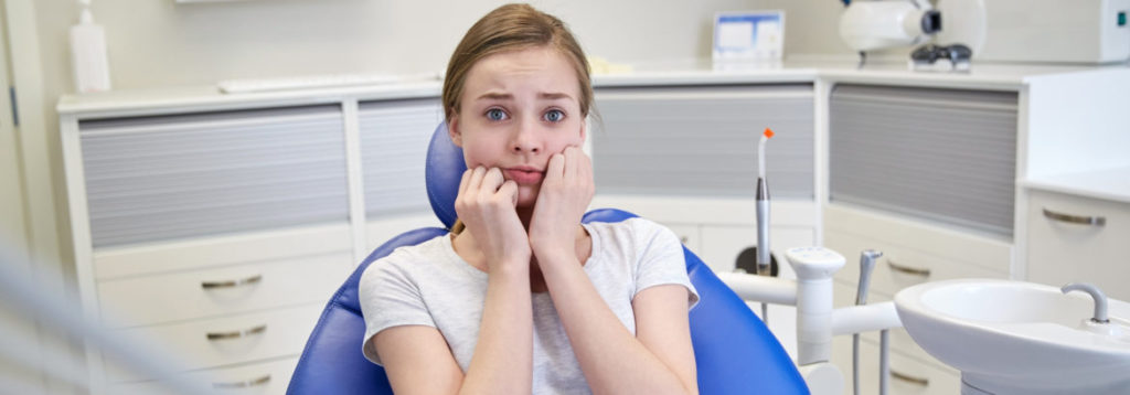 scared and terrified patient girl at dental clinic